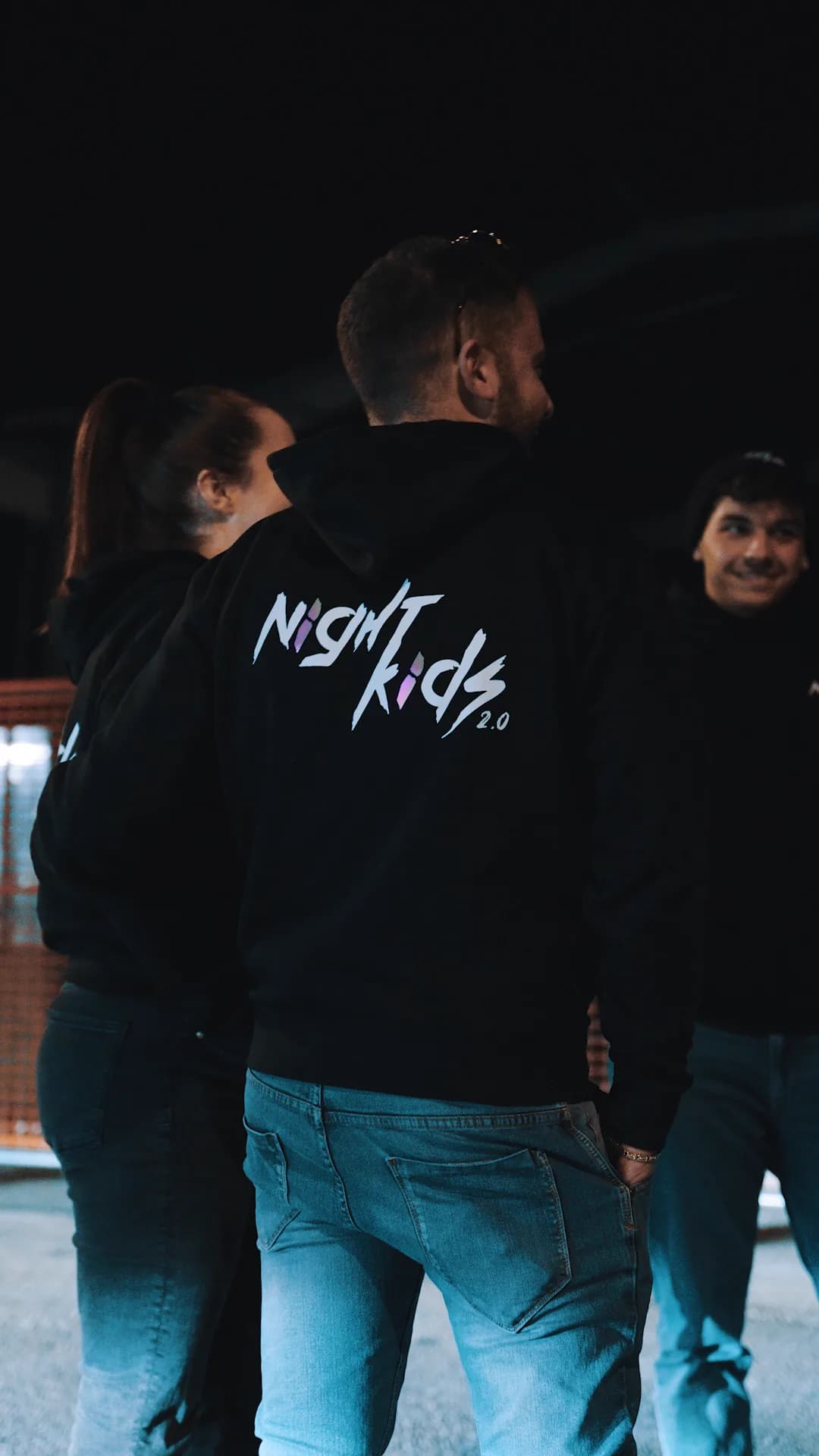 Membri NightKids con la felpa del team, di sera